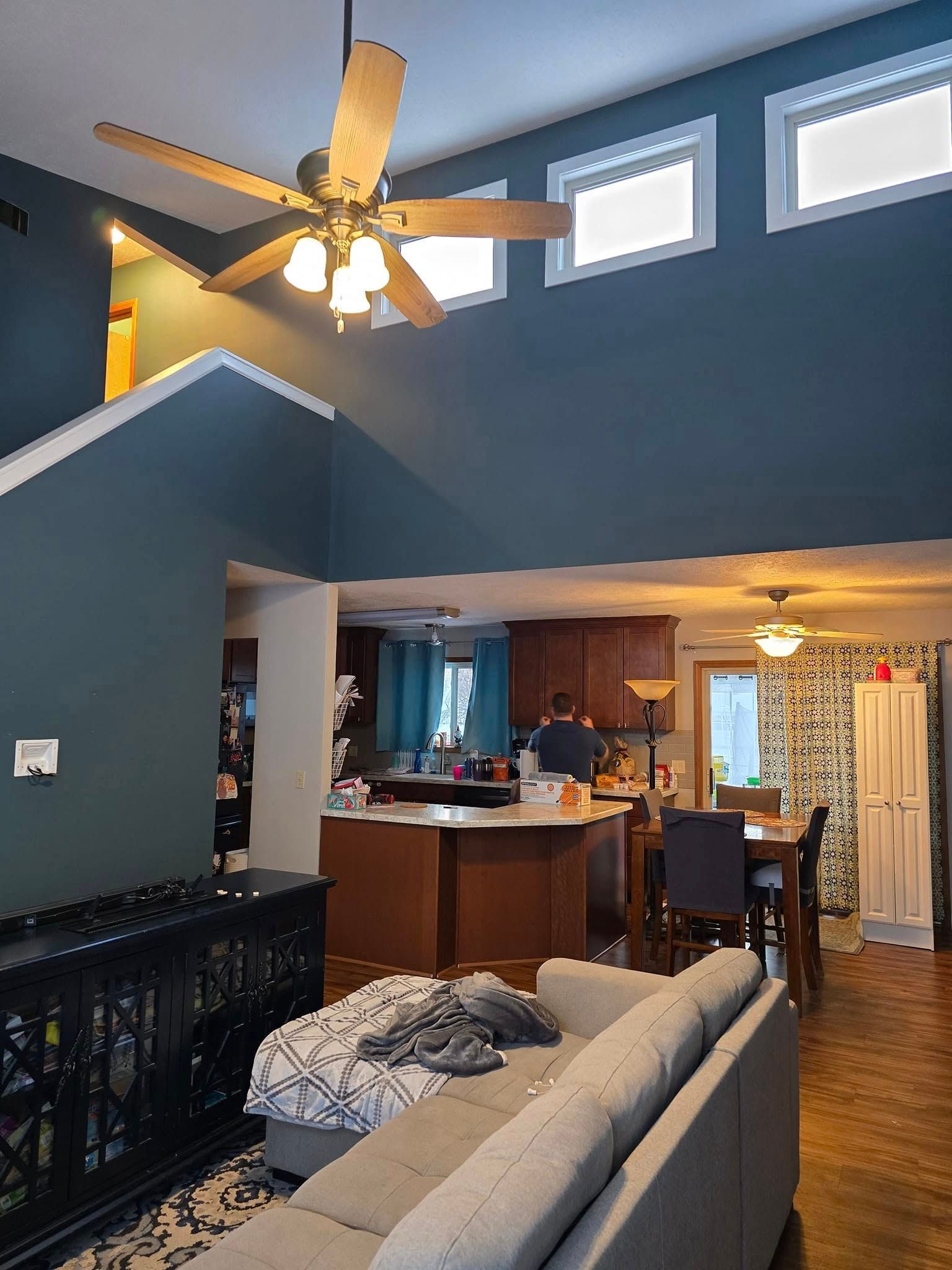 A living room with a couch and a ceiling fan.