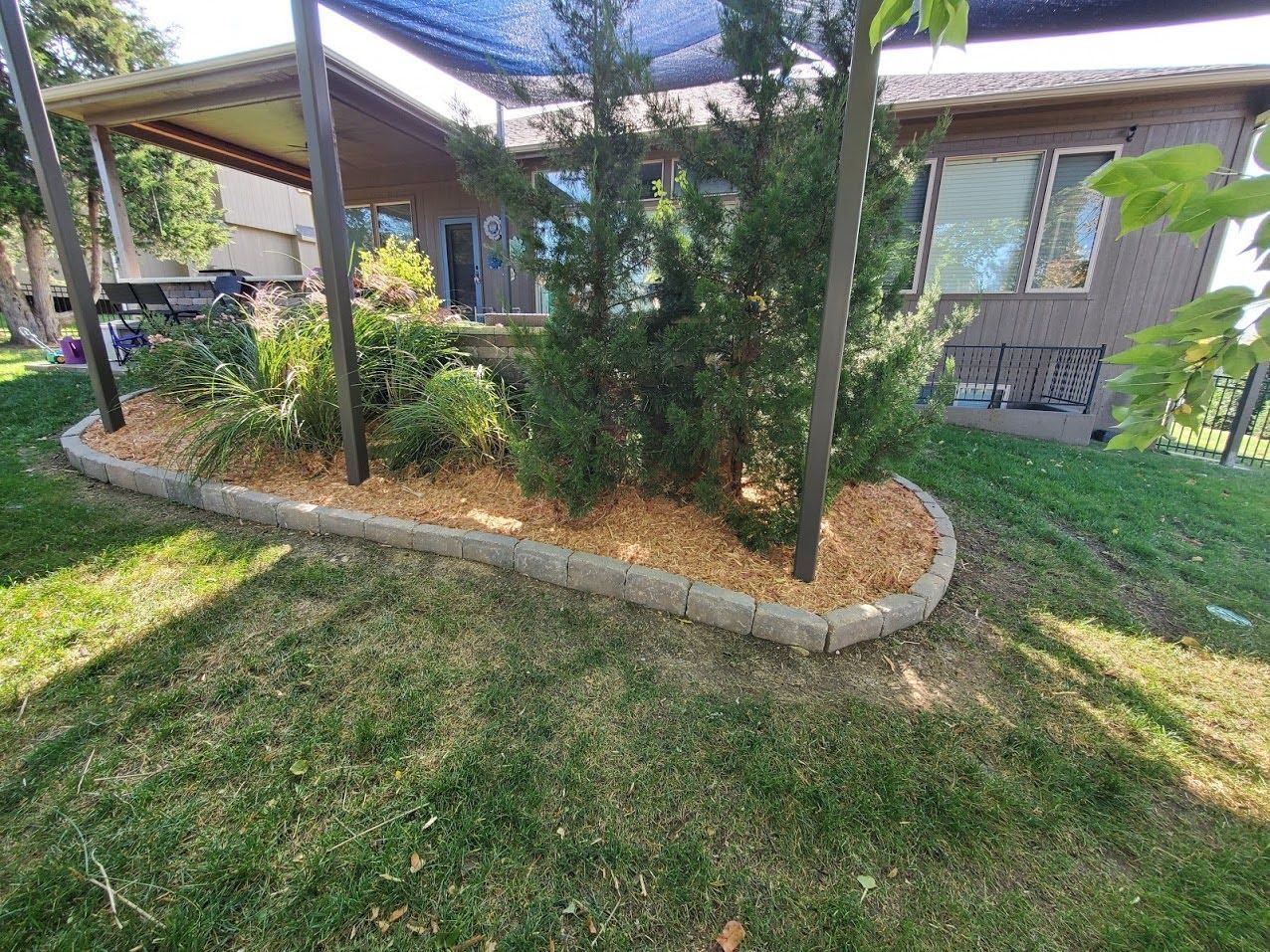 A house with a covered porch and a garden in front of it.