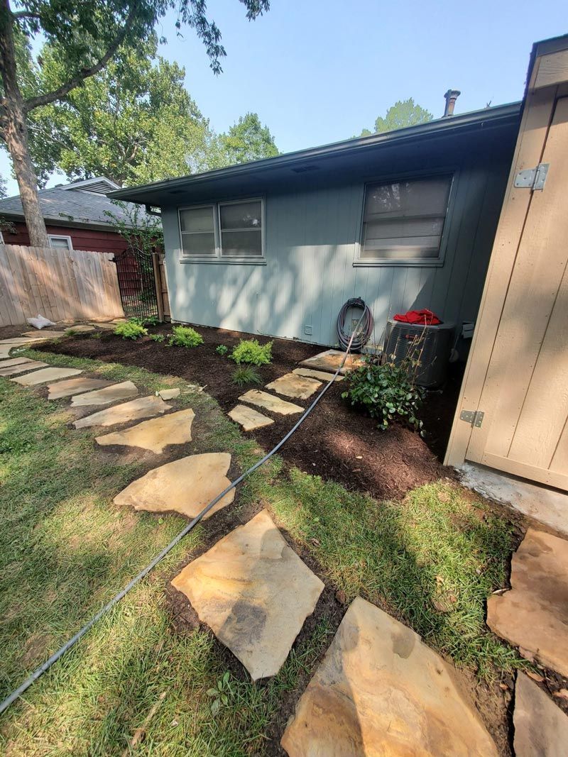 A house with a stone walkway leading to it.