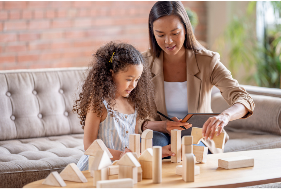 A picture of a woman and a little girl playing with blocks.