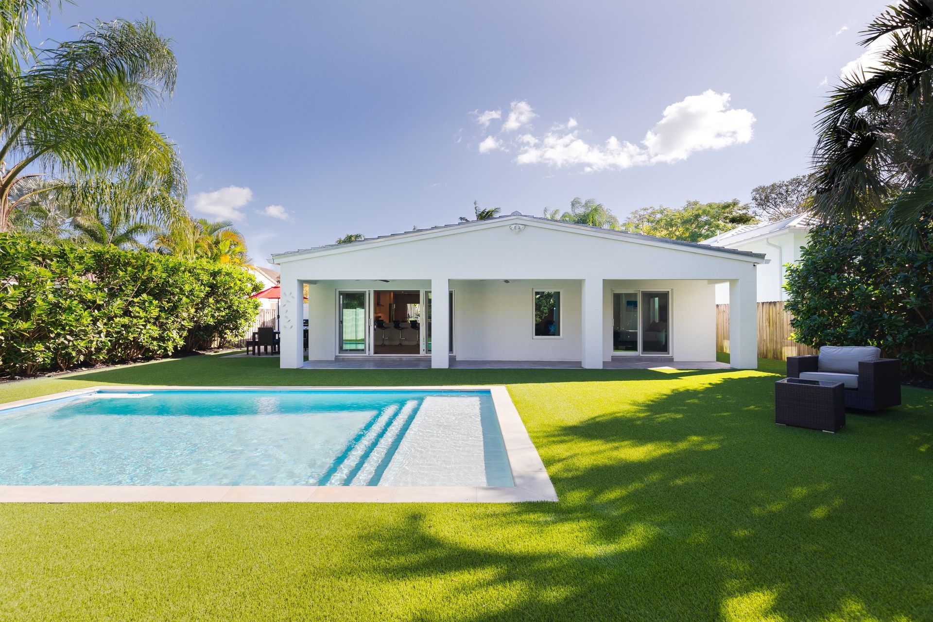 A white house with a swimming pool in the backyard