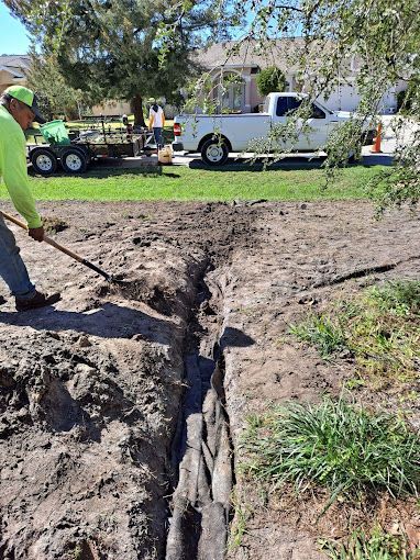 A man is digging a hole in the ground with a shovel.