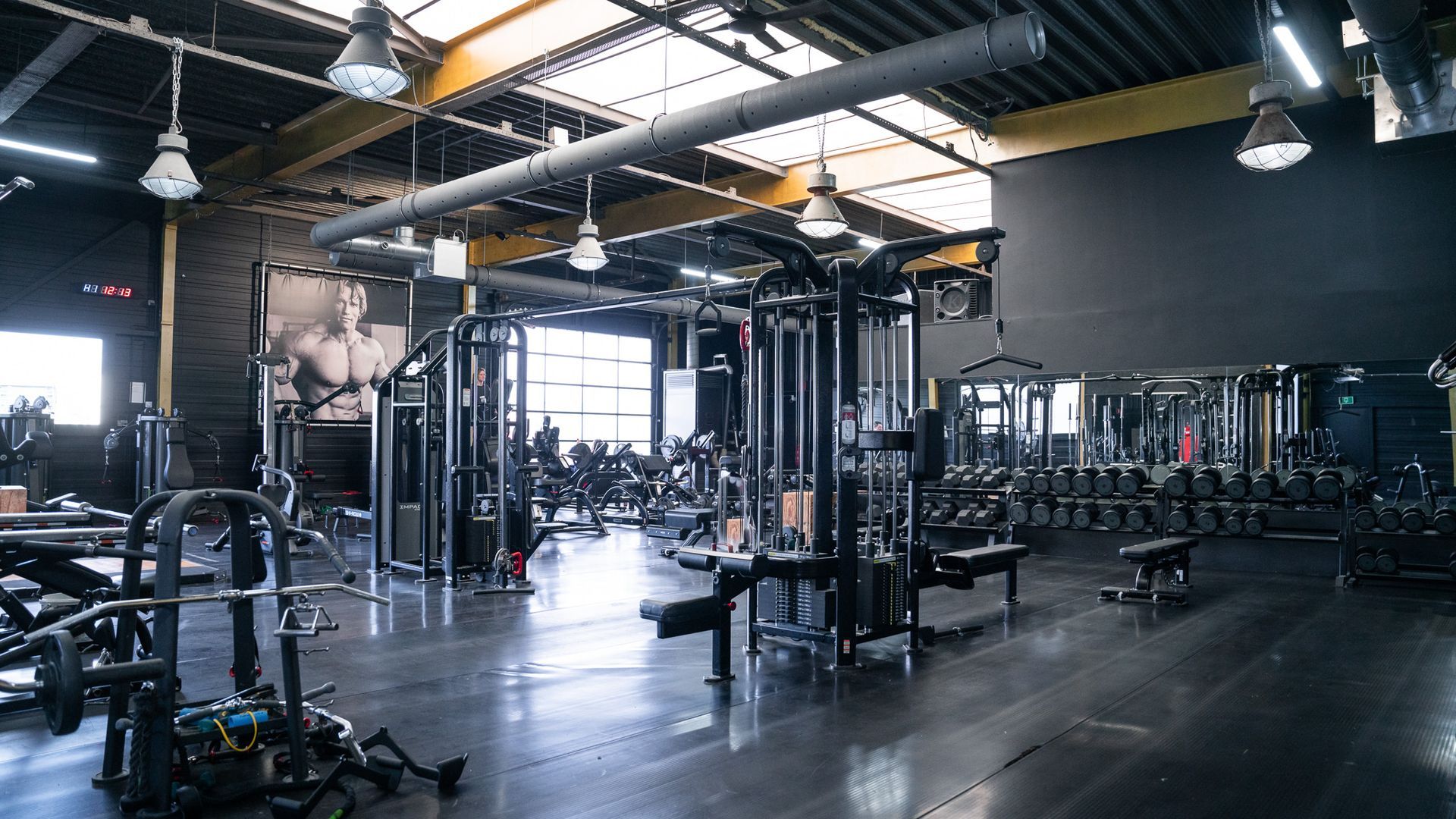 Een grote lege sportschool met veel fitnessapparatuur.