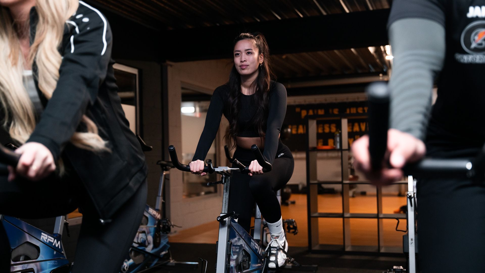 Een groep mensen fietst op een hometrainer in een sportschool.