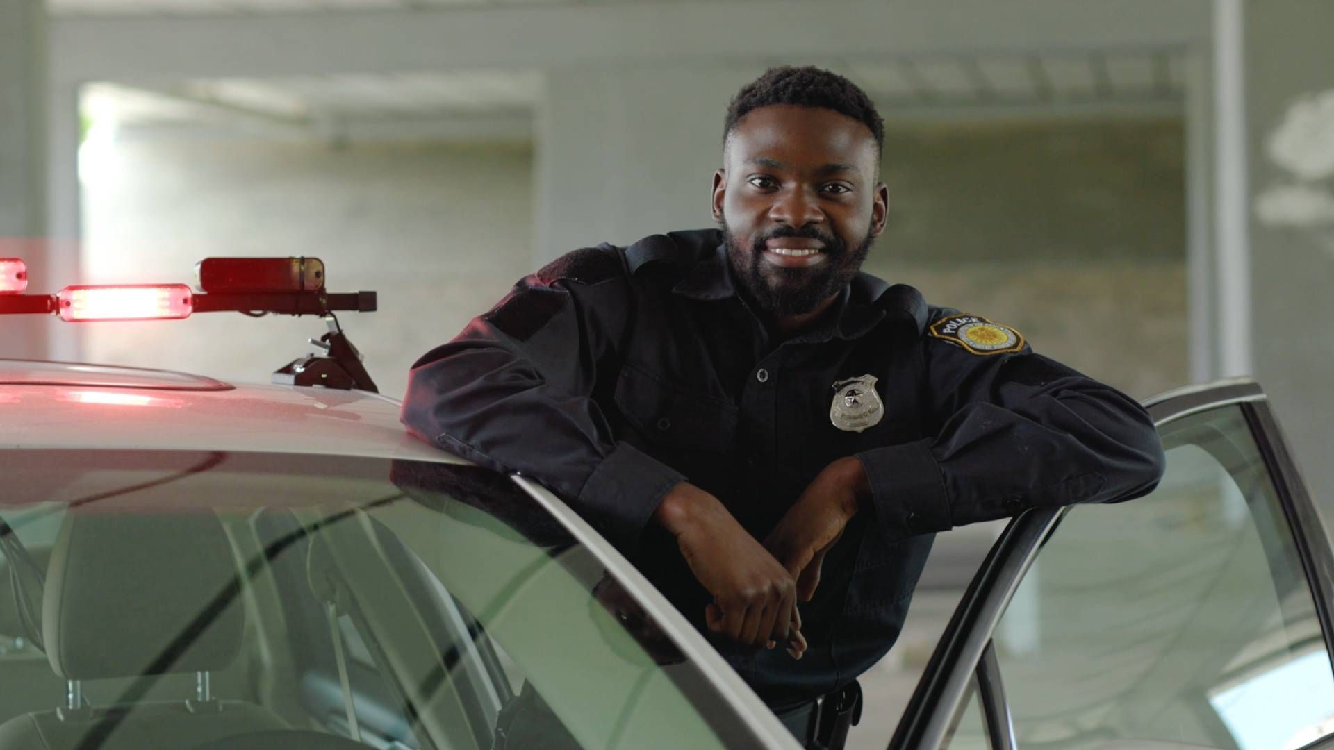 A cop standing near their police cruiser with lights on at TactiTrack GPS near Cincinnati, O