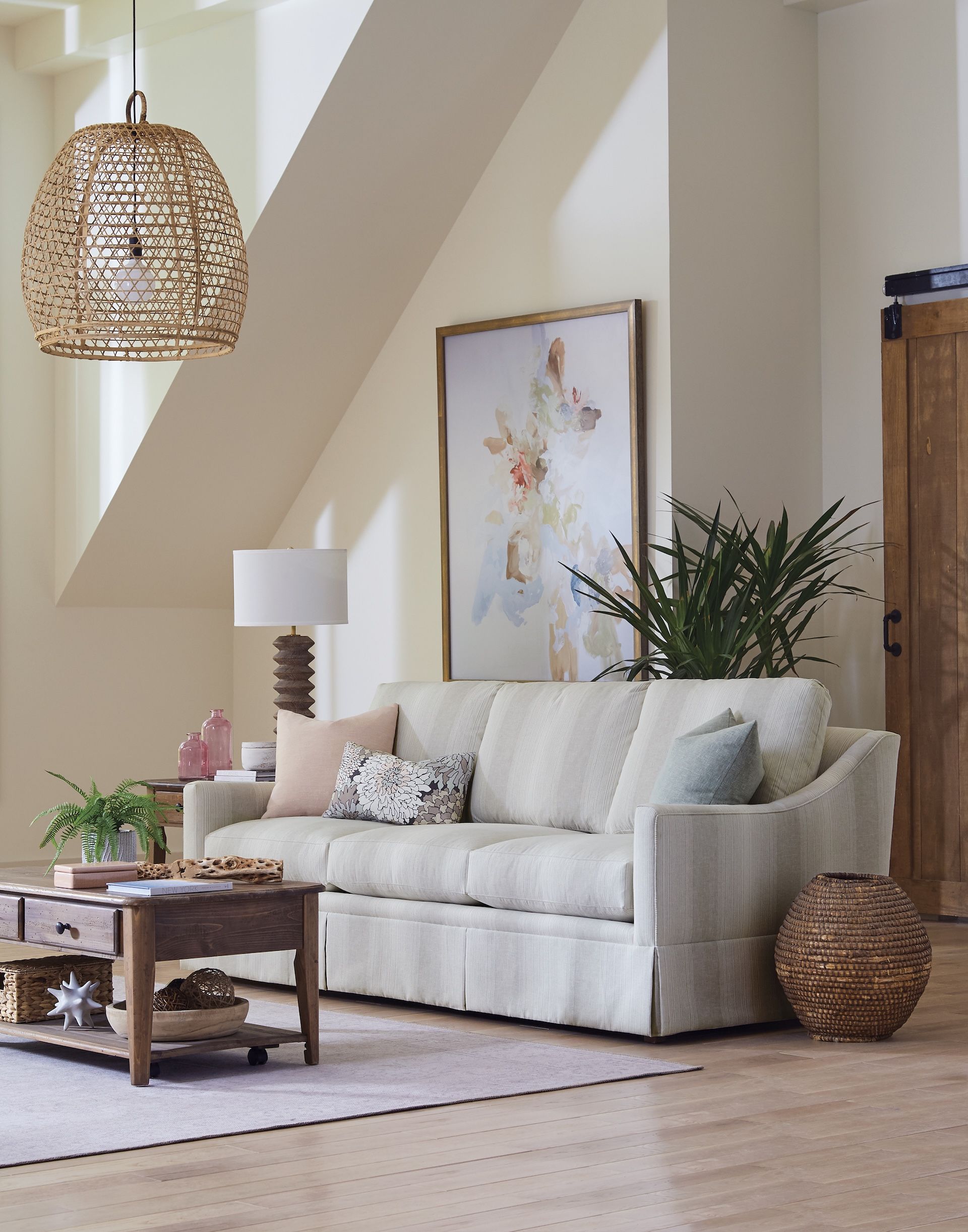 Living room with sofa, artwork, and wooden accent pieces.