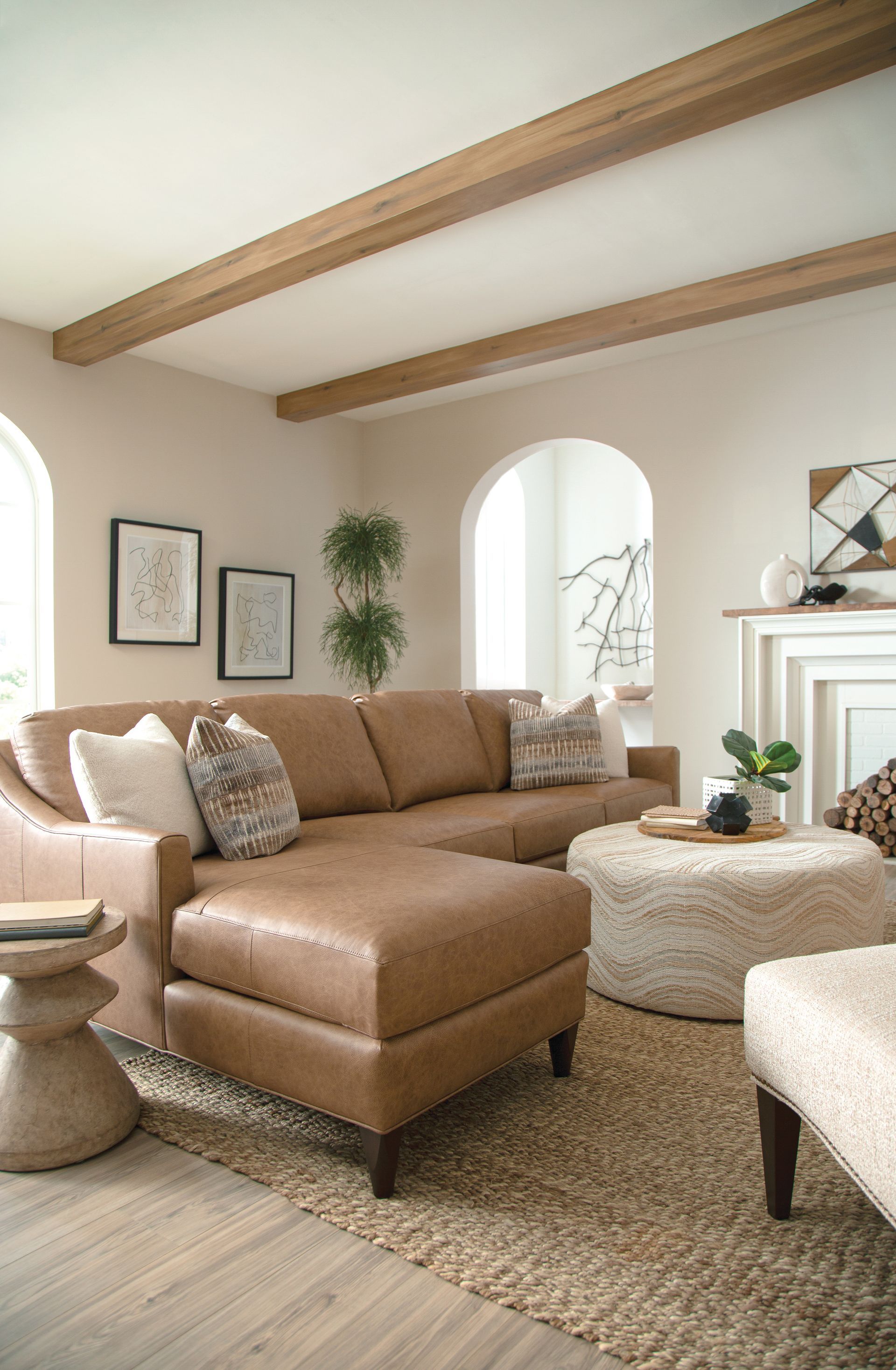 Leather sectional sofa in a living room with jute rug and ottoman.