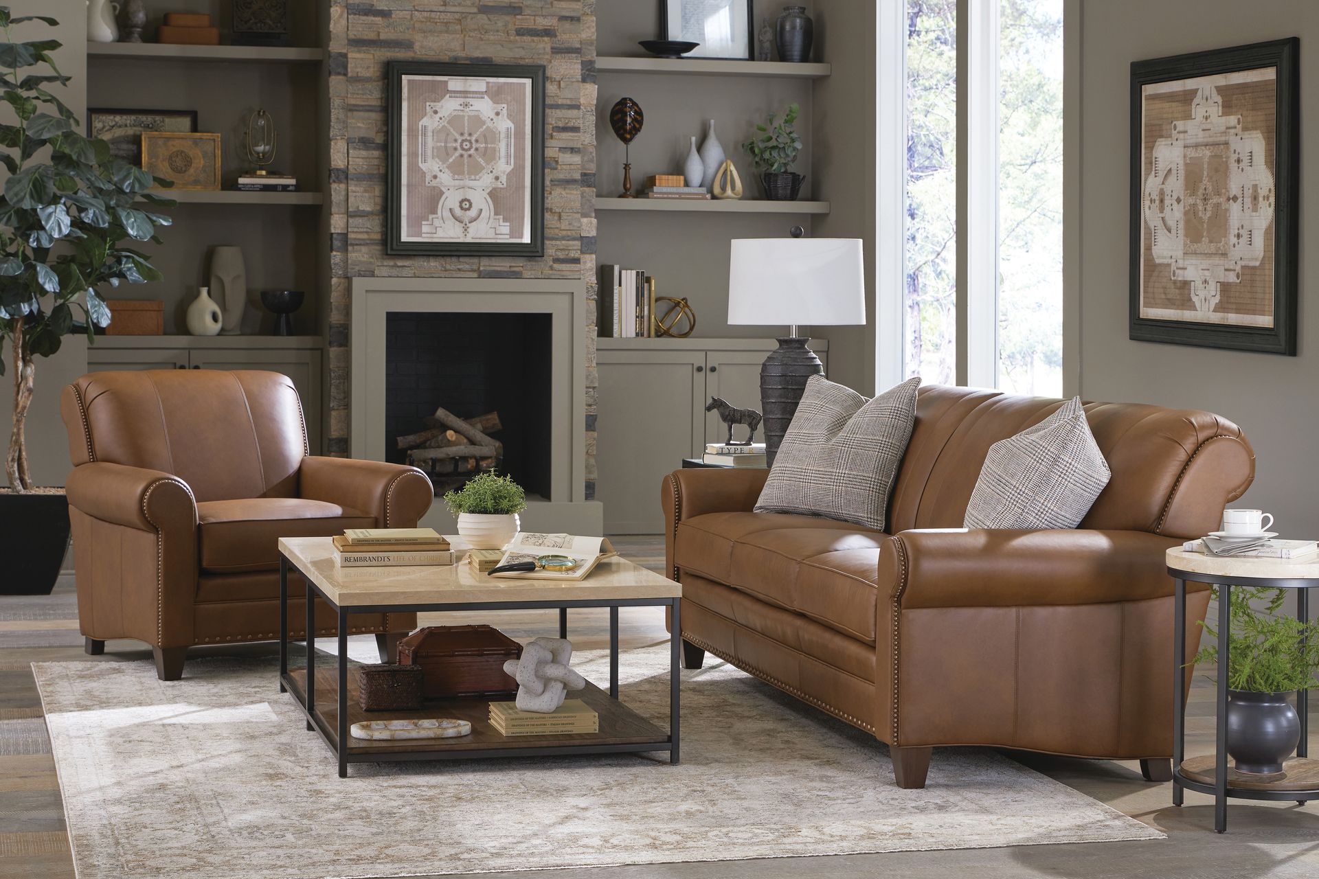 Living room with brown leather sofa, chair, fireplace, and decor.