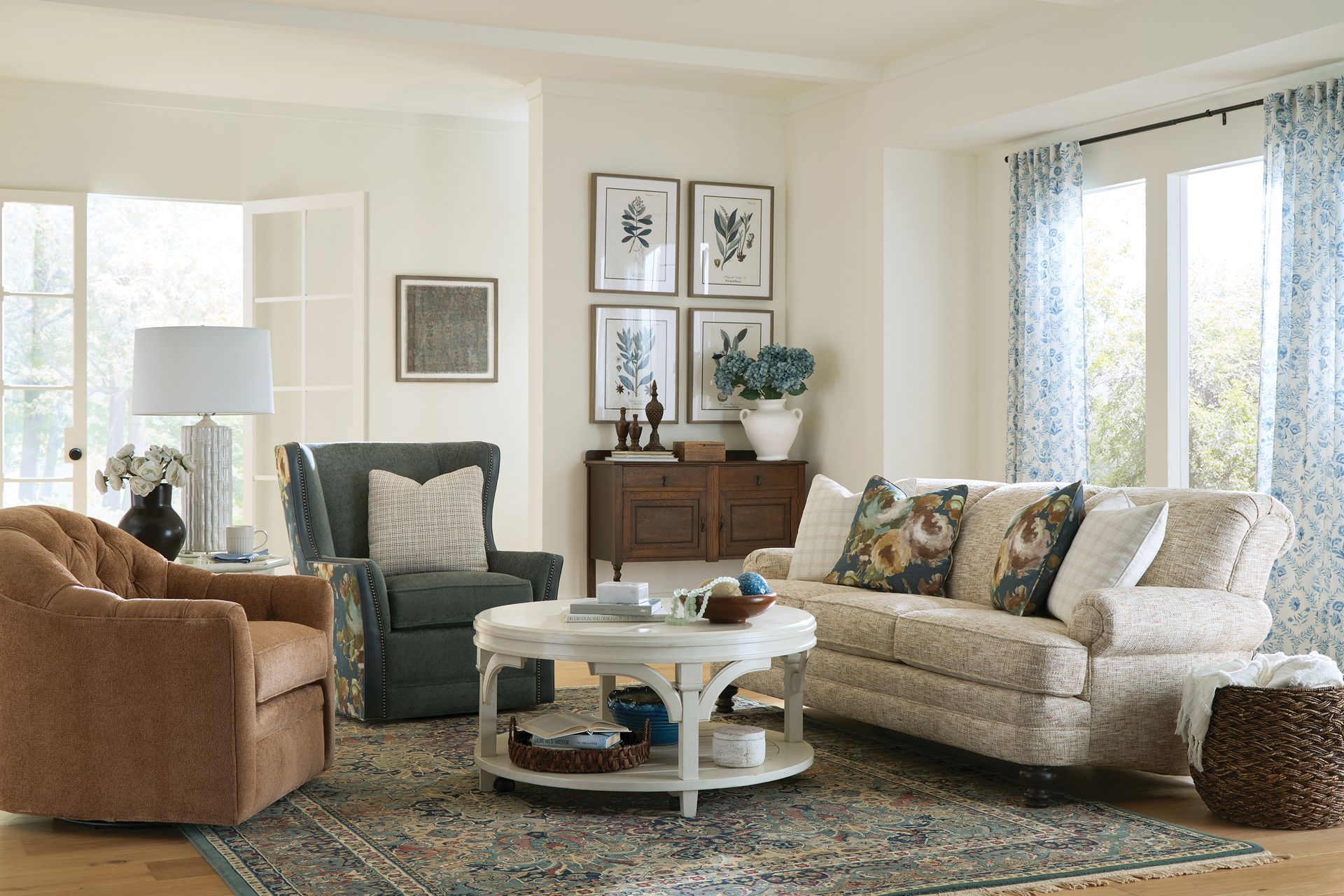 Living room with beige sofa, blue patterned curtains, and brown leather armchair.