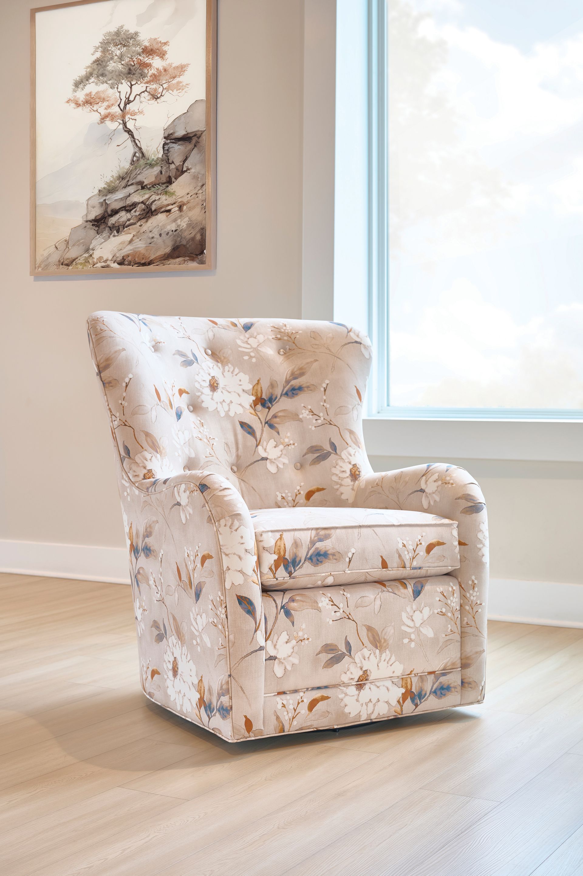 Floral patterned armchair near a window, under a landscape painting.