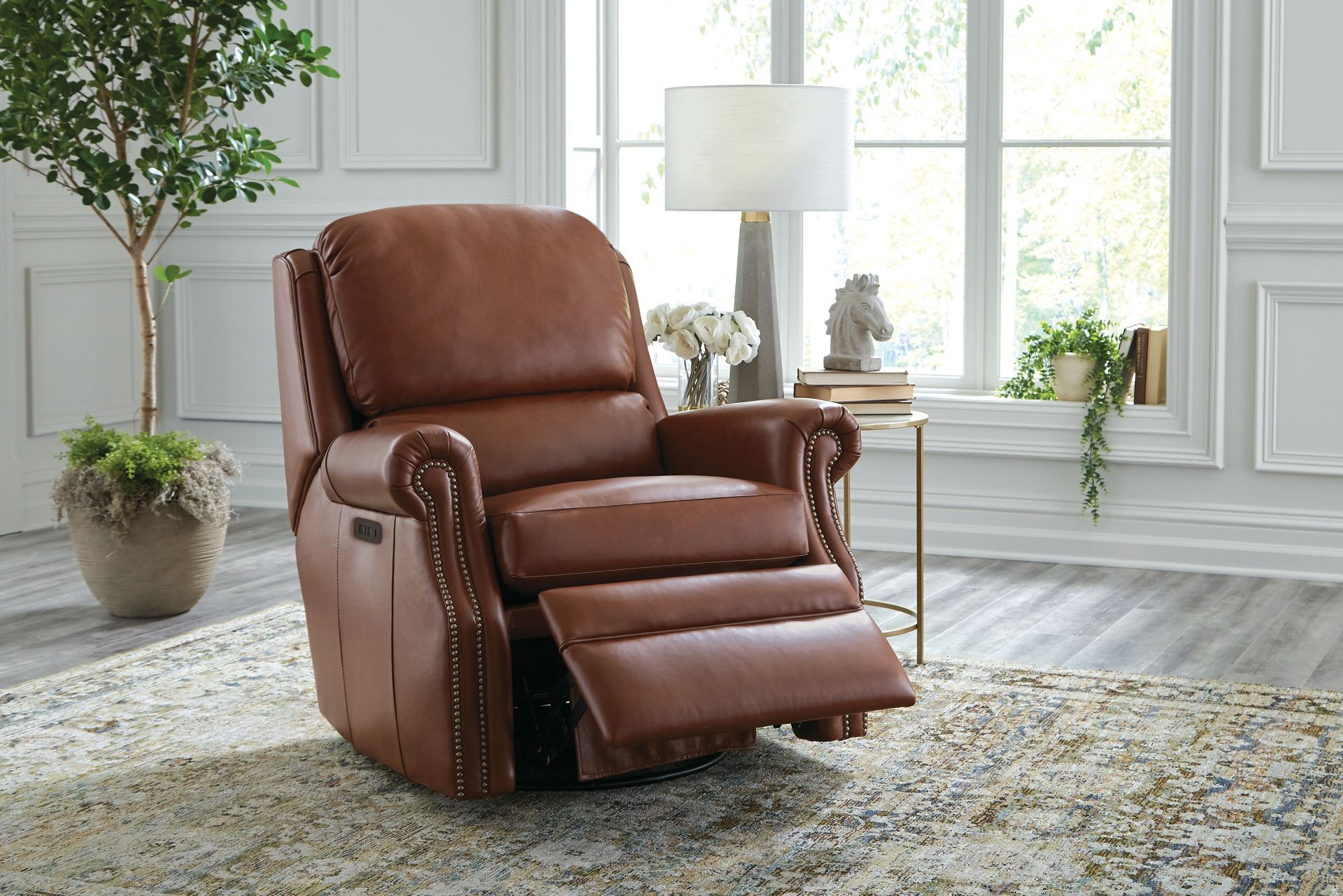 Brown leather recliner in a living room, footrest extended.