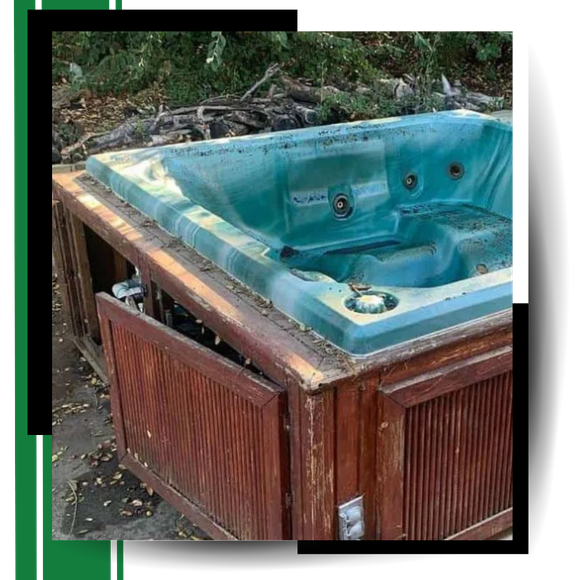 A discarded hot tub with graphics around it.