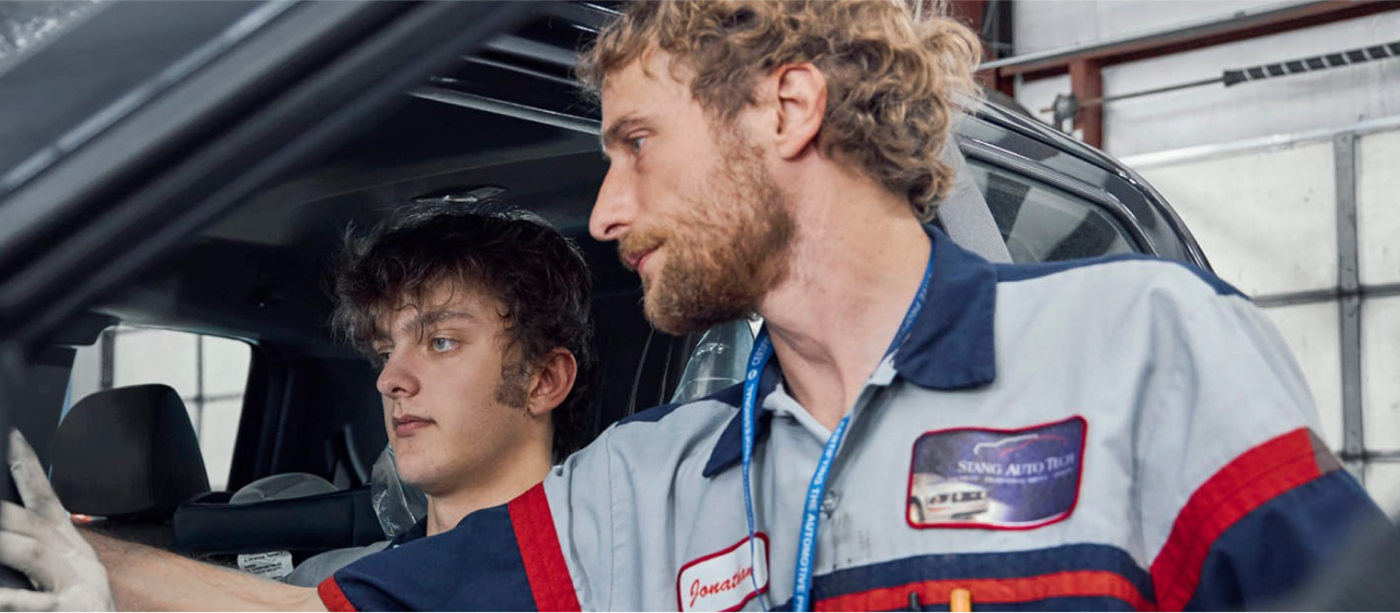 Two mechanics examining a car interior. | Stang Auto Tech