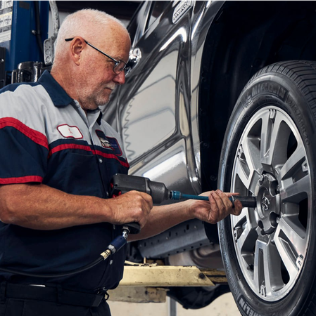 Mechanic removing a tire with a power tool in a garage | Stang Auto Tech