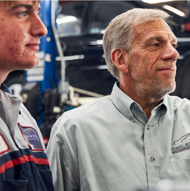 Mechanic mentor with a young apprentice in a garage | Stang Auto Tech