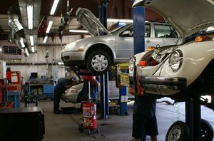 Car repair shop with two cars lifted. | Stang Auto Tech