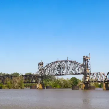 A bridge over a body of water with a blue sky in the background.