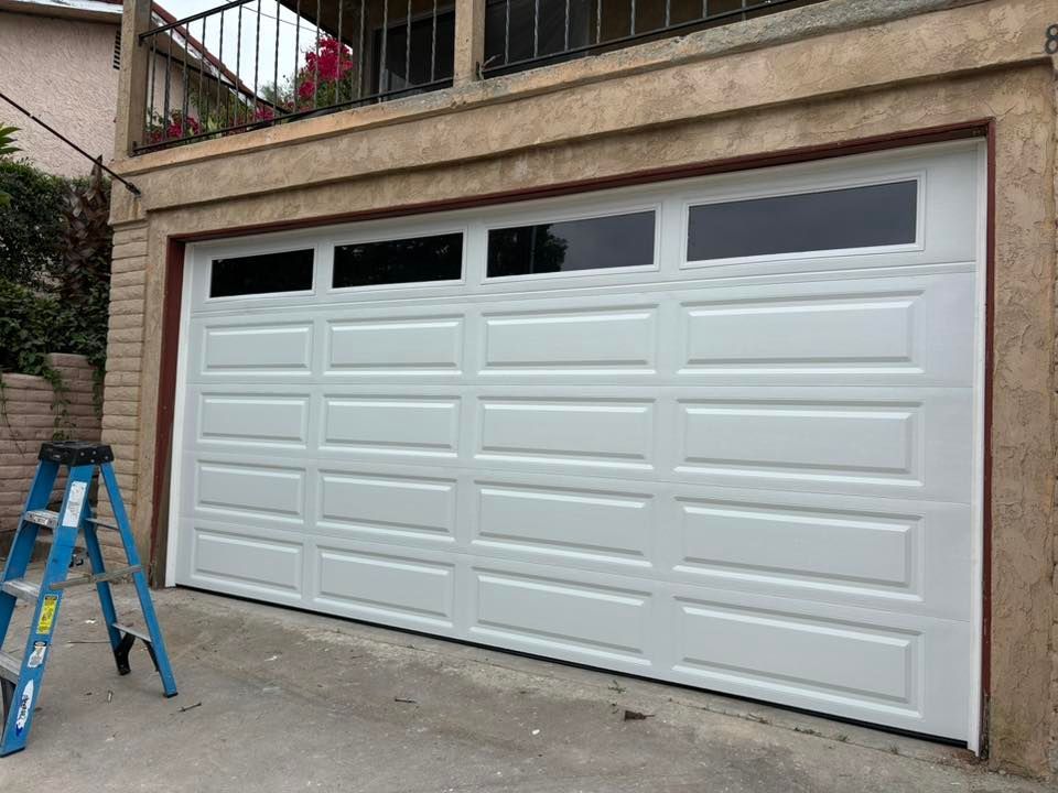 White double garage door on a house exterior, with a blue ladder nearby