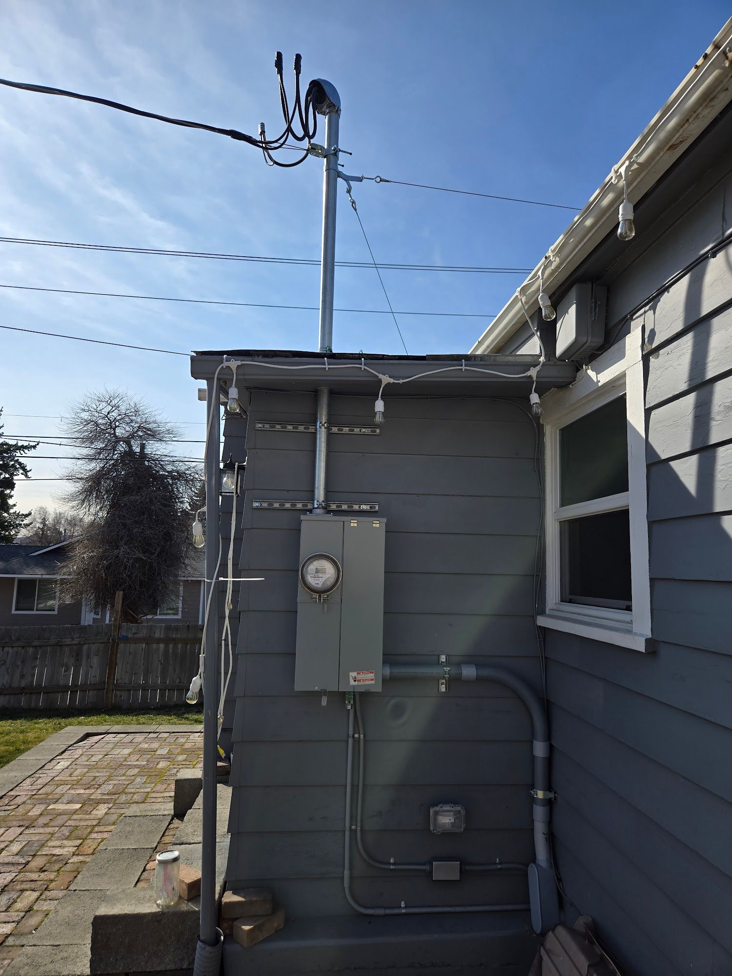 A house with a lot of wires on the side of it.