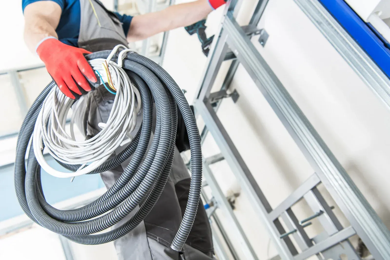 A man is holding a roll of wires in his hands.