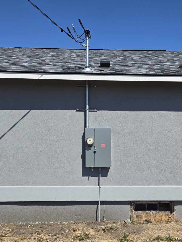 A gray house with a box on the side of it