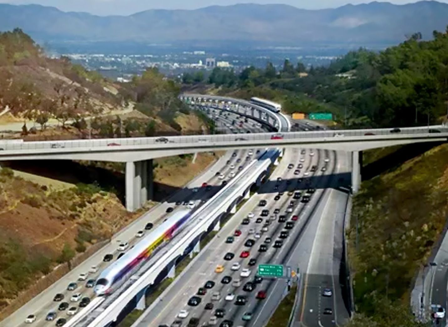 an aerial view of a highway with mountains in the background