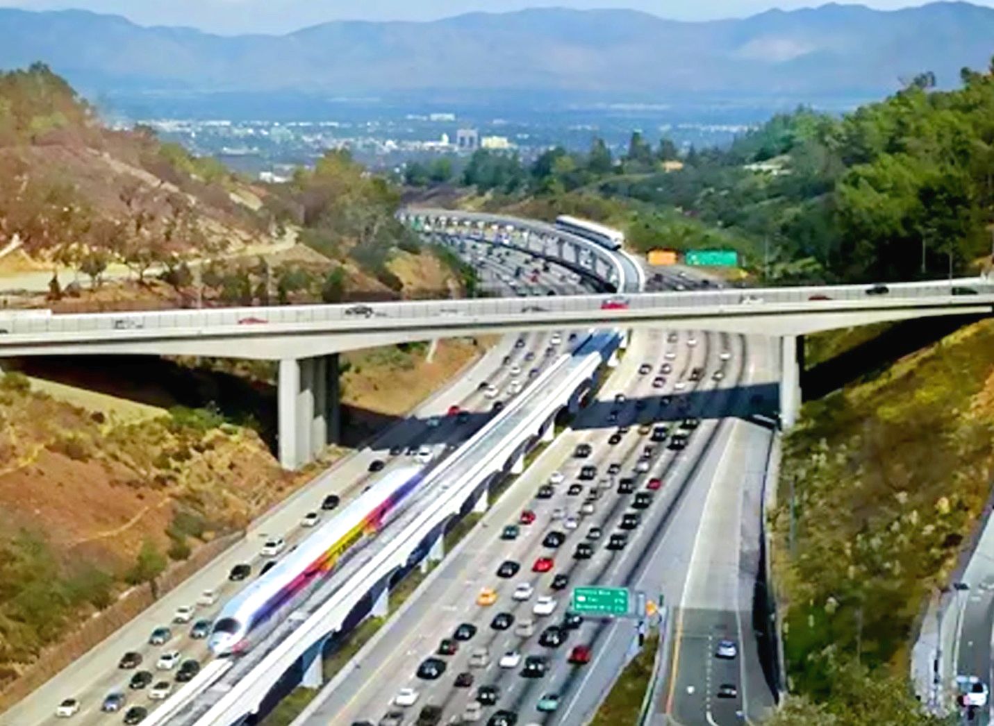 an aerial view of a highway with mountains in the background