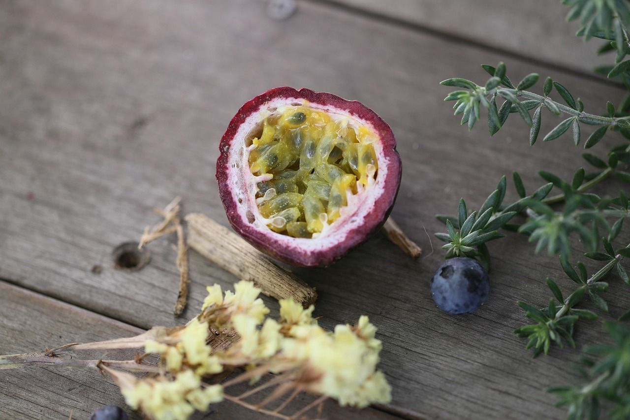A passion fruit is cut in half on a wooden table.
