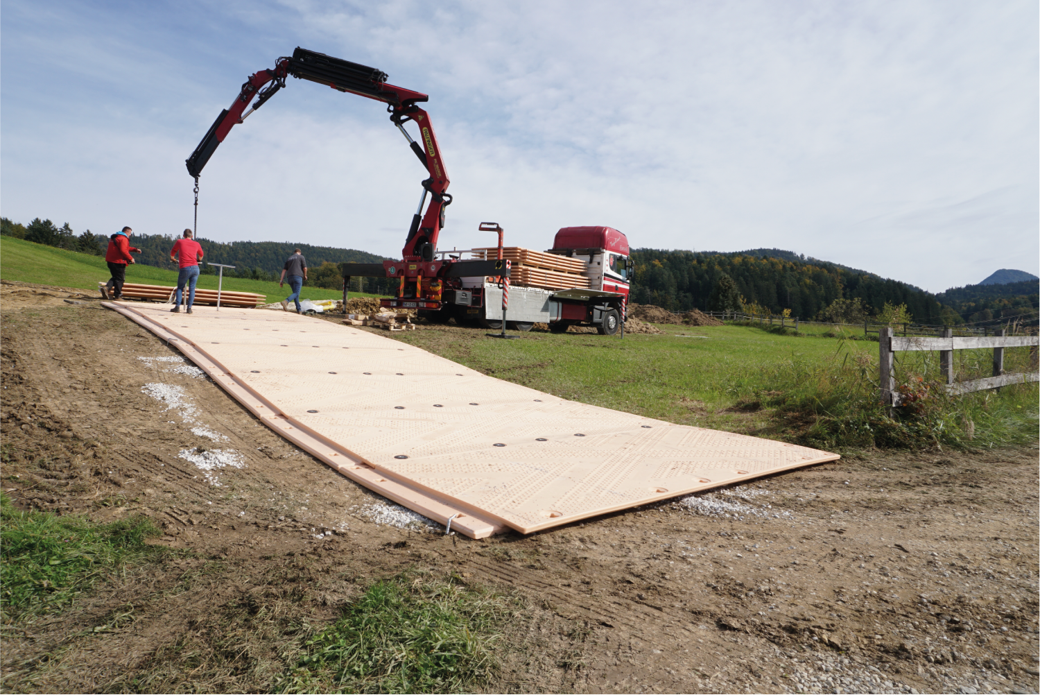 Una grúa está levantando un trozo de madera y poniéndolo en un camión.