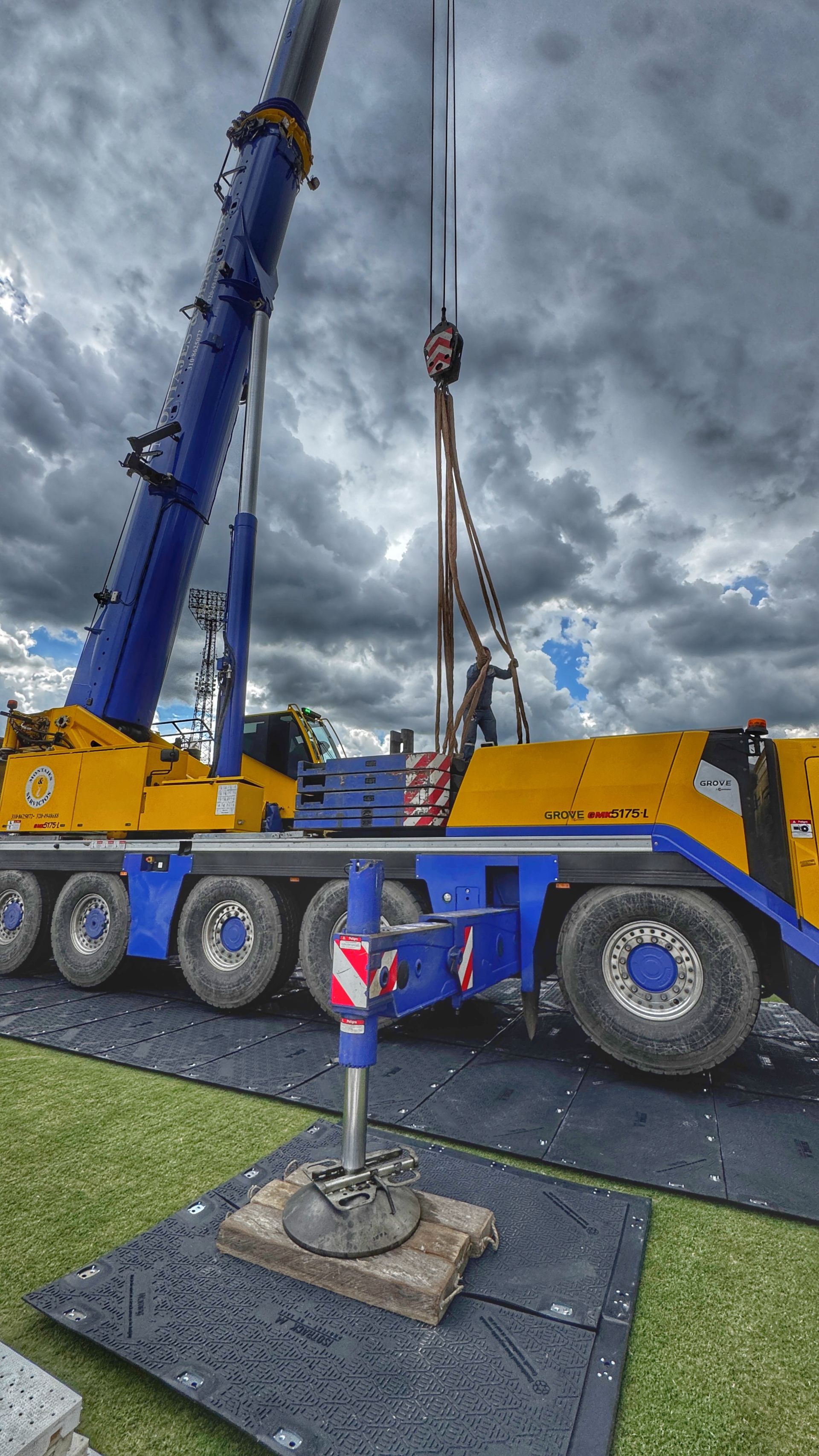 Un tractor azul avanza por un camino de Isotrack sobre tierra al lado de un campo.