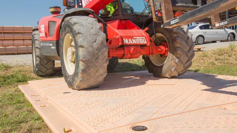 Un tractor rojo está sentado encima de una alfombra de Isotrack.