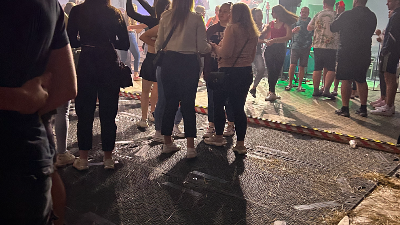 Un grupo de personas se encuentran entre una multitud en una fiesta sobre Isotrack.