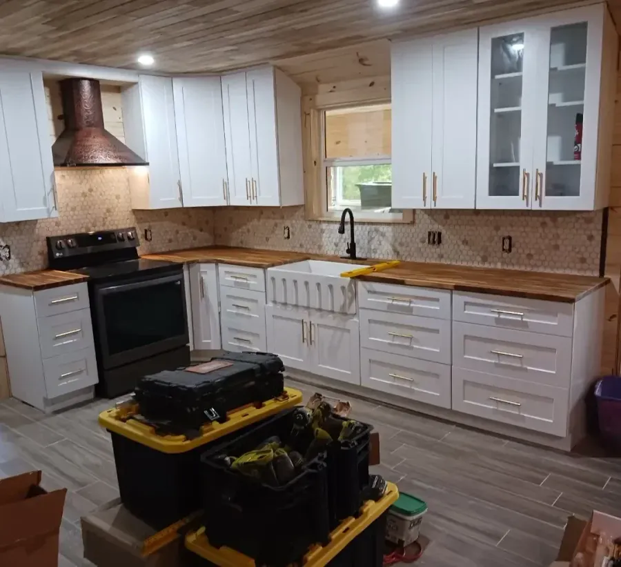 A kitchen with white cabinets and a black stove