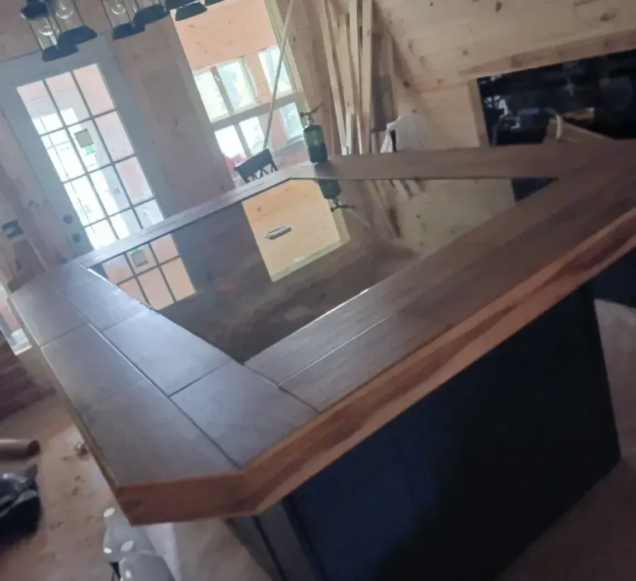 A kitchen with a wooden counter top and a stainless steel sink.