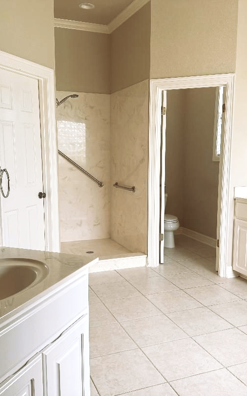 A woman in a blue apron is cleaning a table with a cloth.