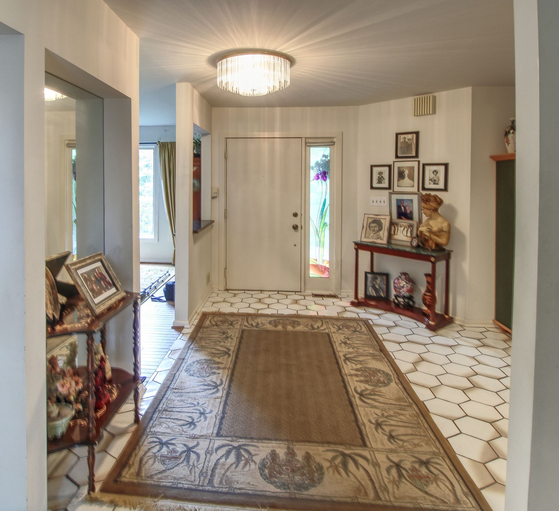 A hallway with a rug and pictures on the wall