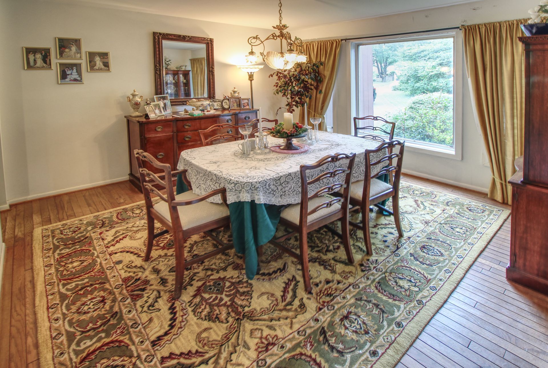 A dining room with a table and chairs and a rug.