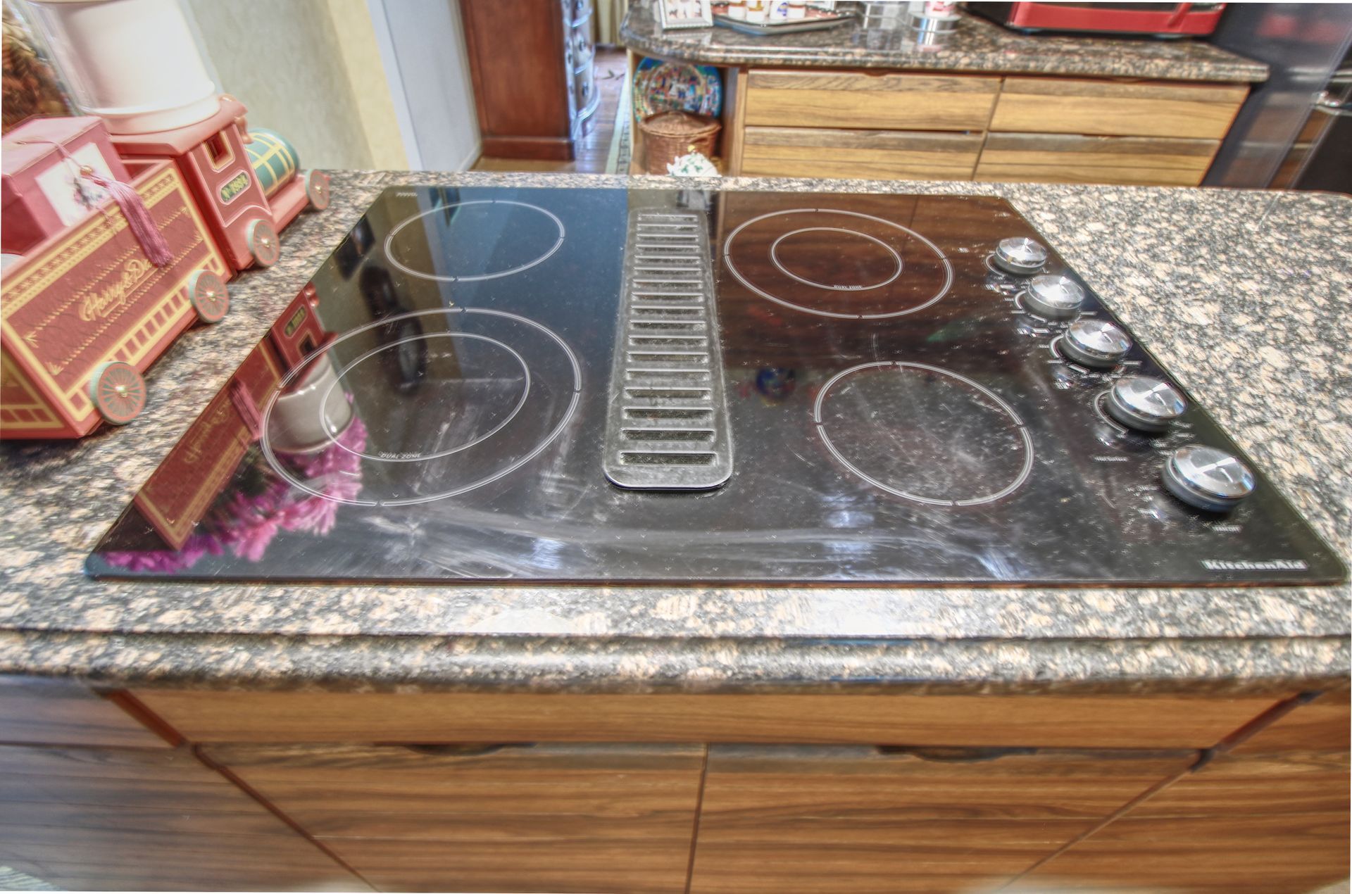 A stove top oven is sitting on top of a granite counter in a kitchen.