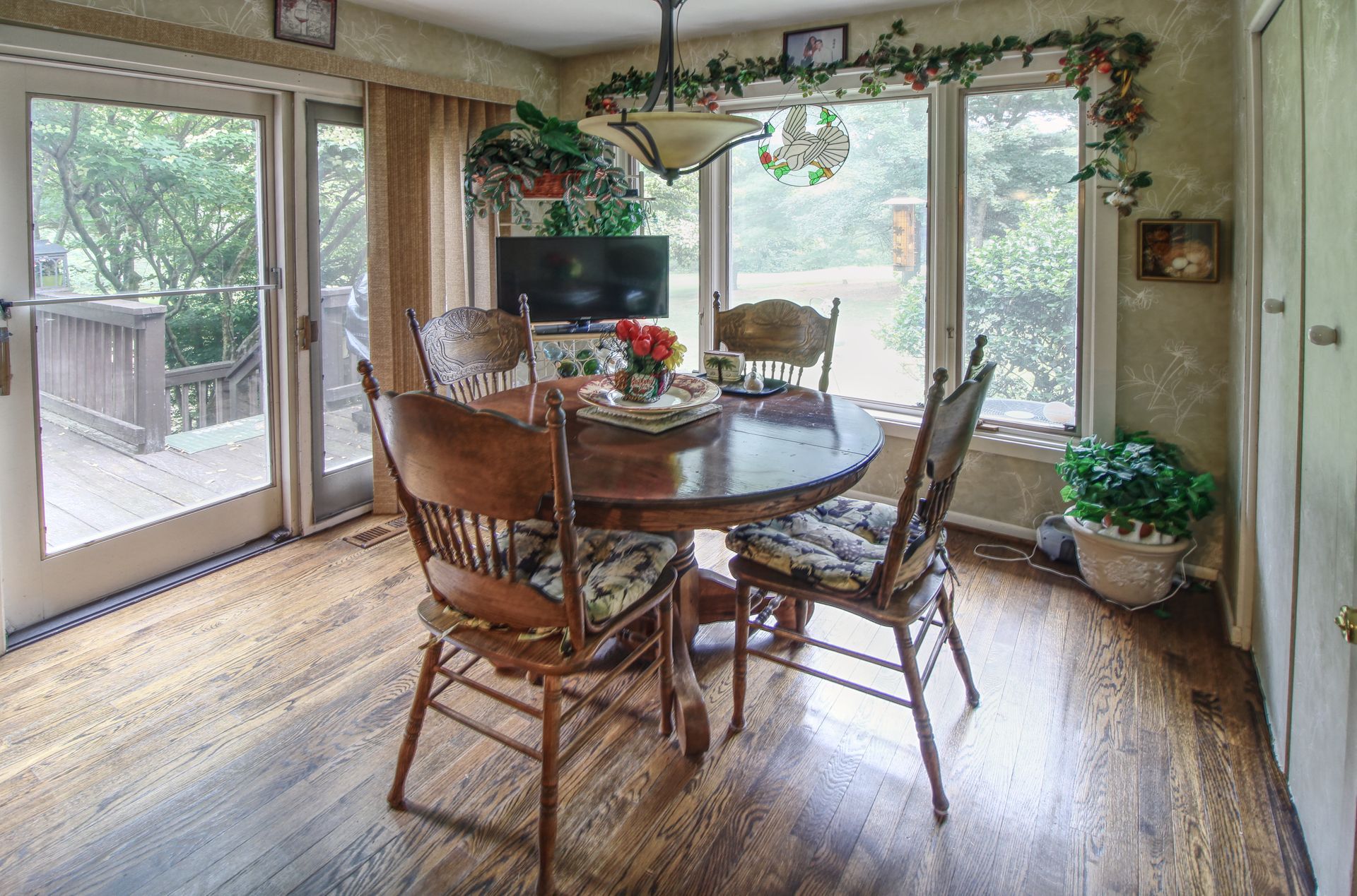 A dining room with a table and chairs and a lot of windows.