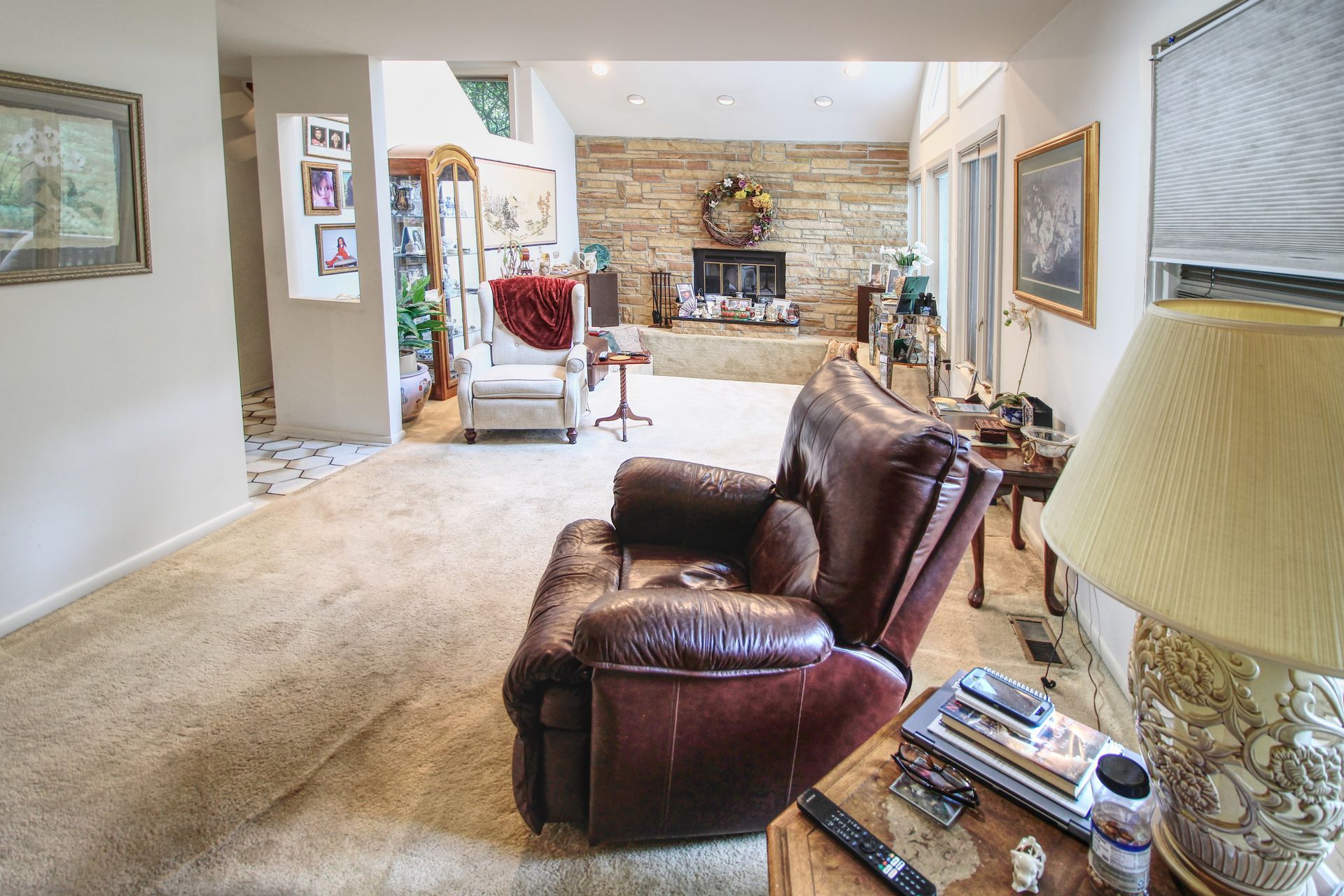 A living room with a brown leather recliner and a lamp.