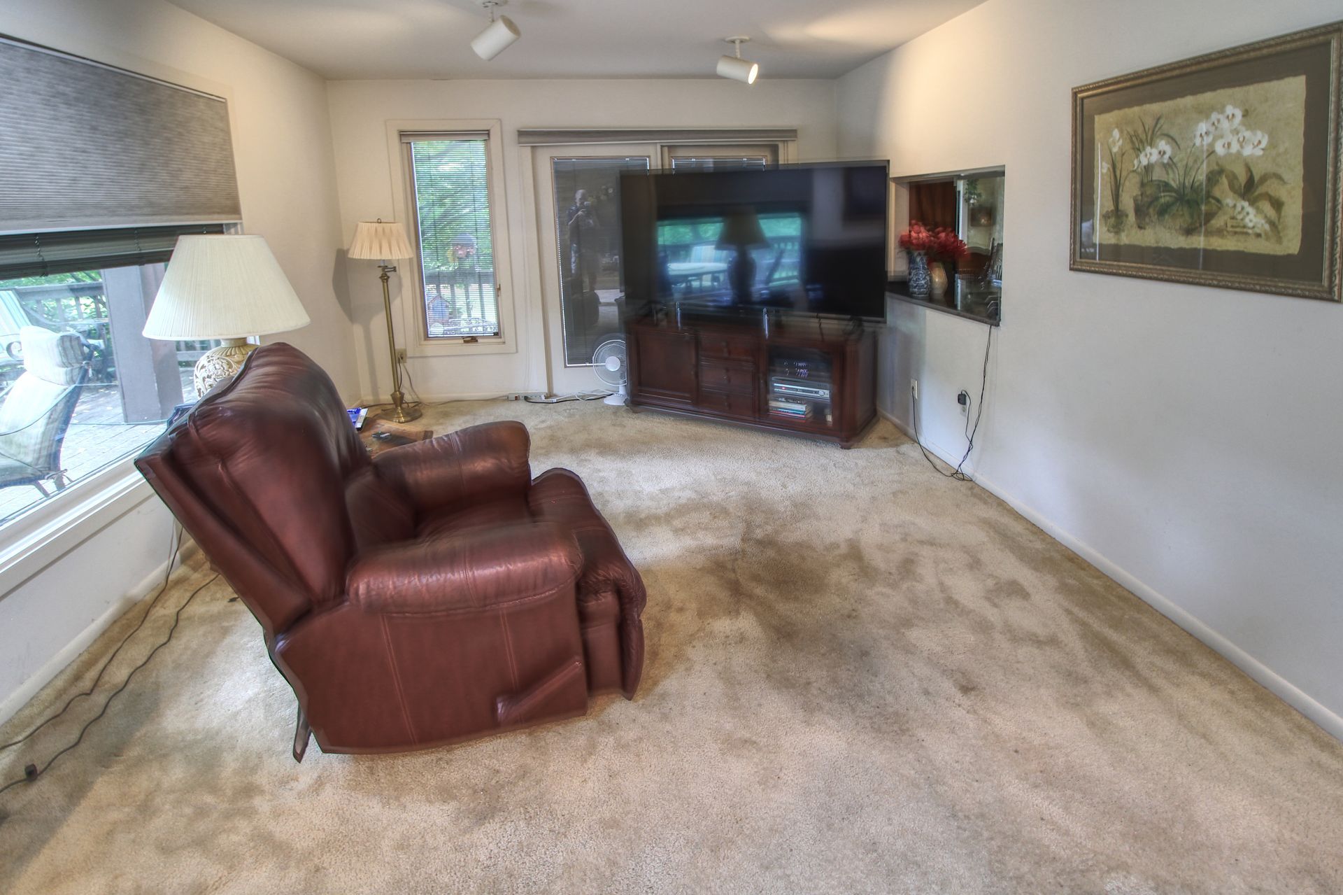 A living room with a brown recliner and a flat screen tv