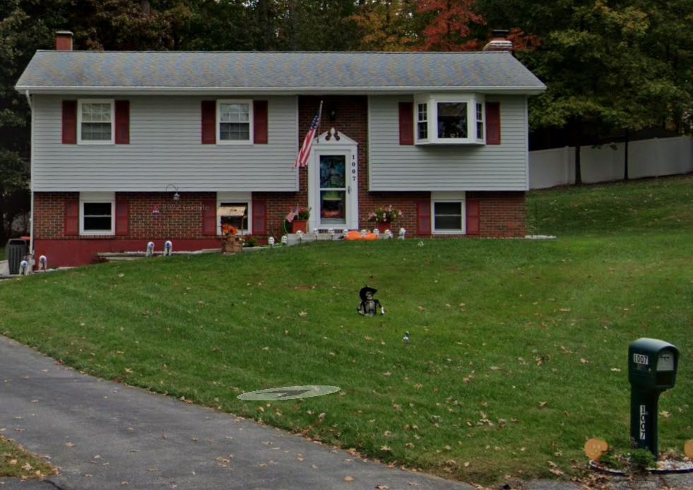 A house with a large lawn and a mailbox in front of it