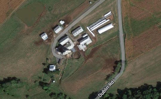 An aerial view of a farm with a road going through it.