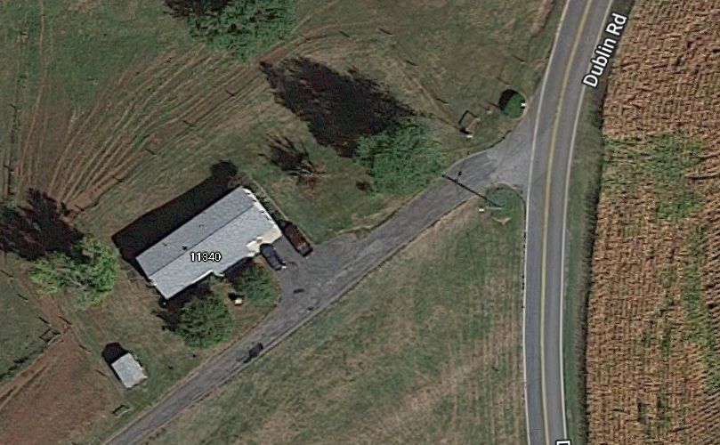 An aerial view of a house next to a road