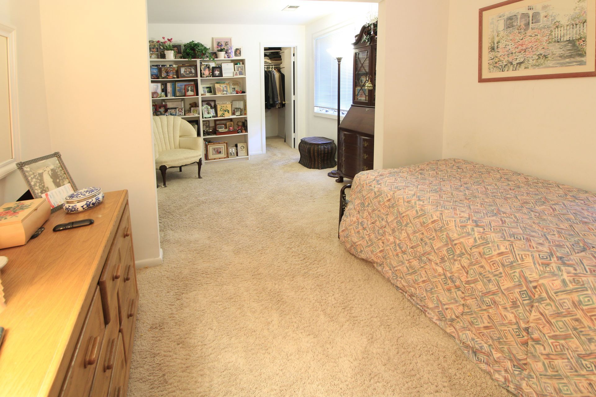 A bedroom with a single bed and a dresser