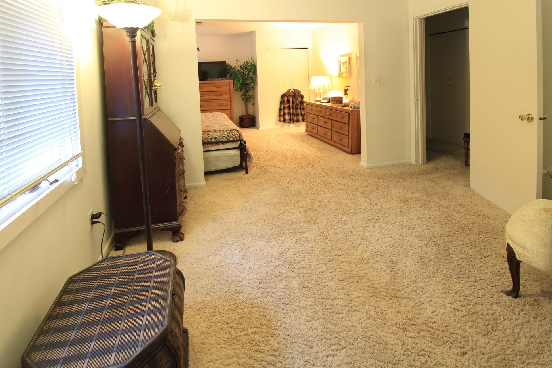 A bedroom with a dresser and a lamp