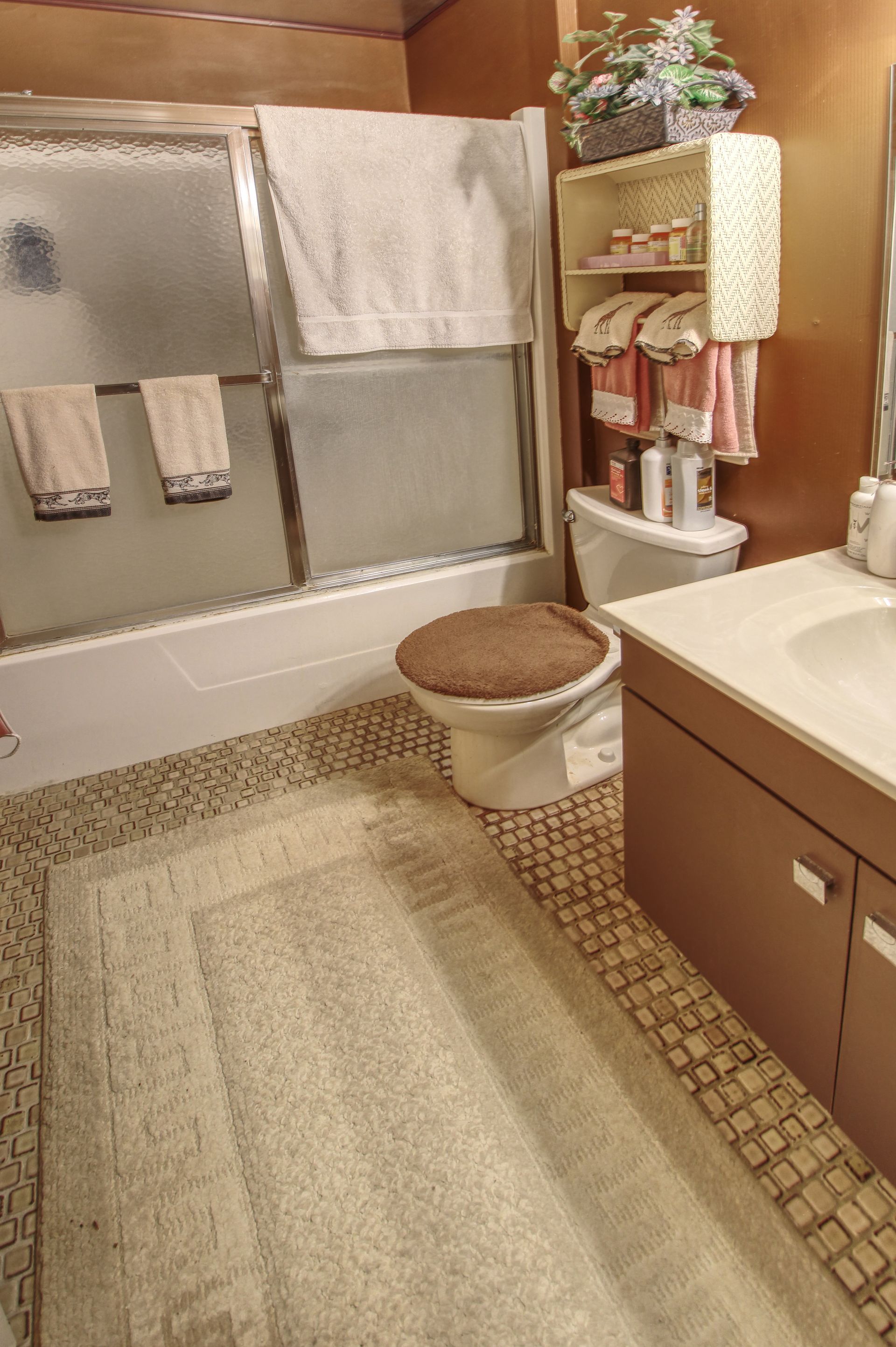 A bathroom with a toilet , sink , and shower.