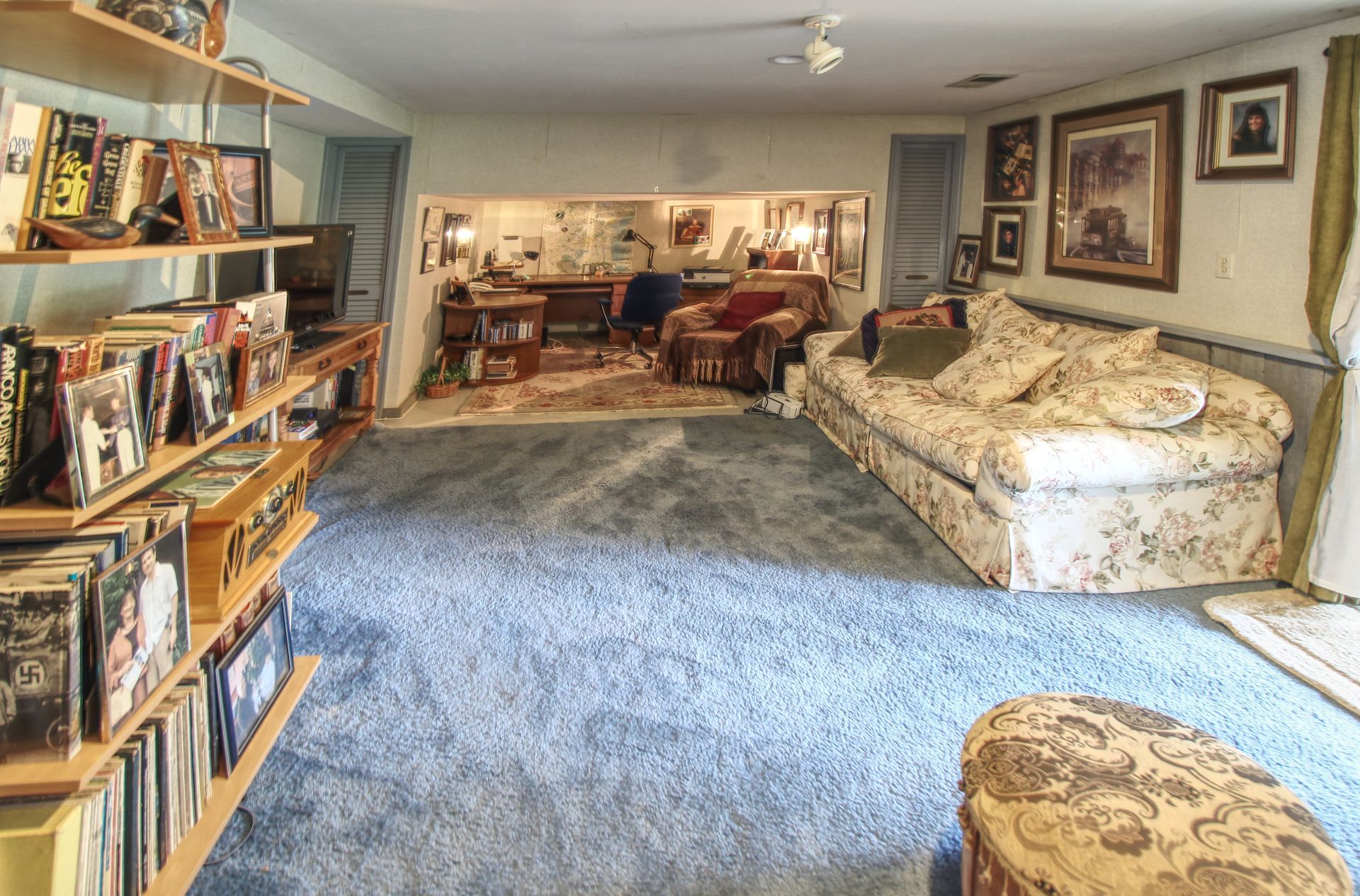 A living room with a couch and shelves full of books