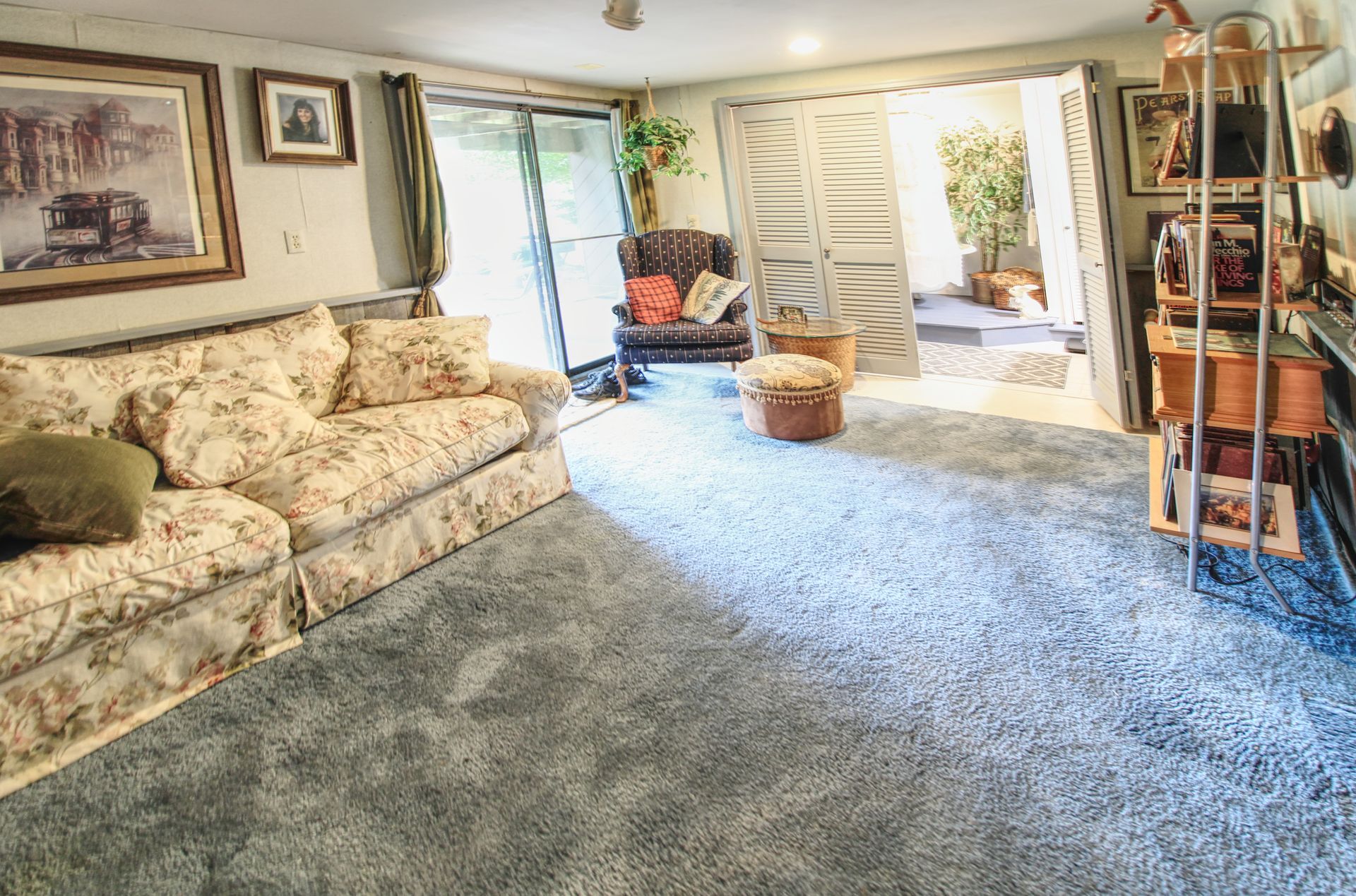 A living room with a couch and chairs and a sliding glass door