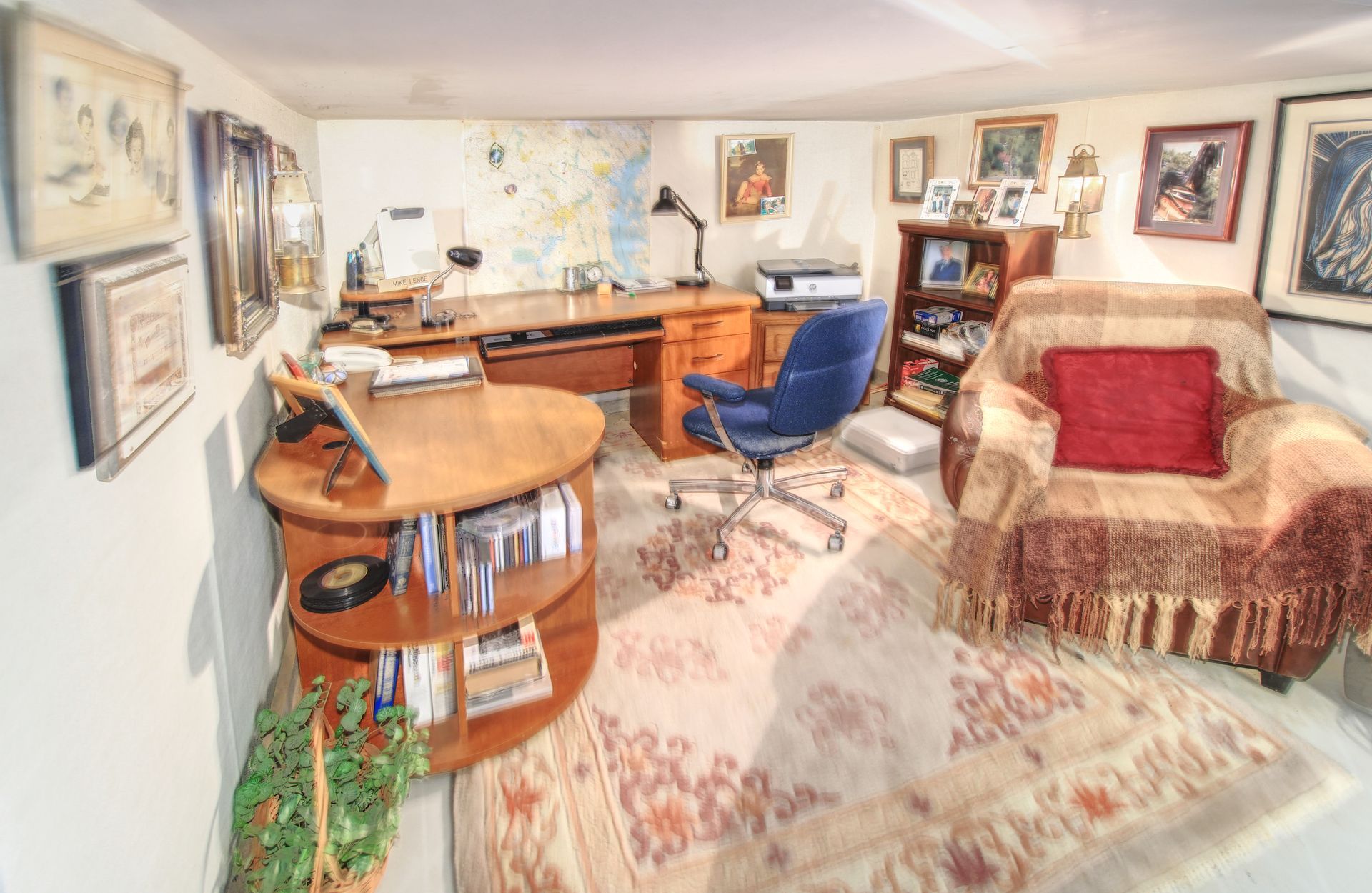 A living room with a desk a chair and a rug